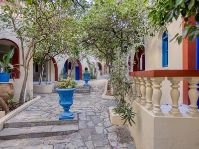 Charming cobblestone path with blue and white buildings and greenery in a Mediterranean street.