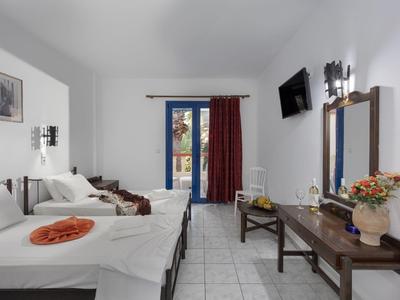 Camera d'hotel luminosa con letto matrimoniale, divano, TV a schermo piatto e vista sul balcone.