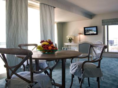 Coin repas avec table ronde en bois, chaises et corbeille de fruits dans un intérieur moderne avec vue sur balcon