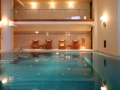 Piscine intérieure avec chaises longues et lumière chaude dans une ambiance d'hôtel relaxante