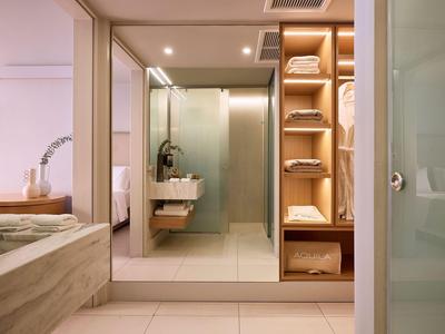 Modernes Badezimmer mit Glasdusche, Regal mit Handtüchern und Badewanne.