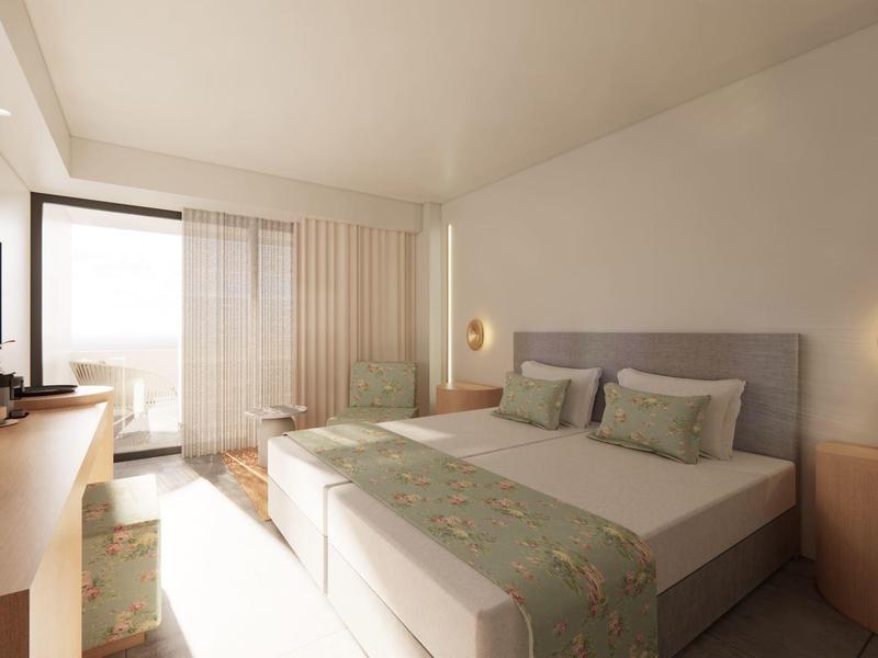 Chambre d'hôtel lumineuse avec lit double, bureau, télévision et accès au balcon.