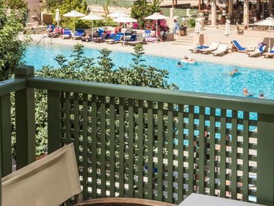 Basen w ośrodku z leżakami, parasolami i budynkami nad morzem w słoneczny dzień.