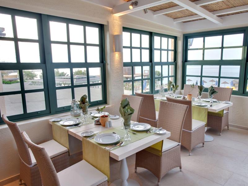 Nowoczesna jadalnia z dużymi oknami i nakrytymi stołami.