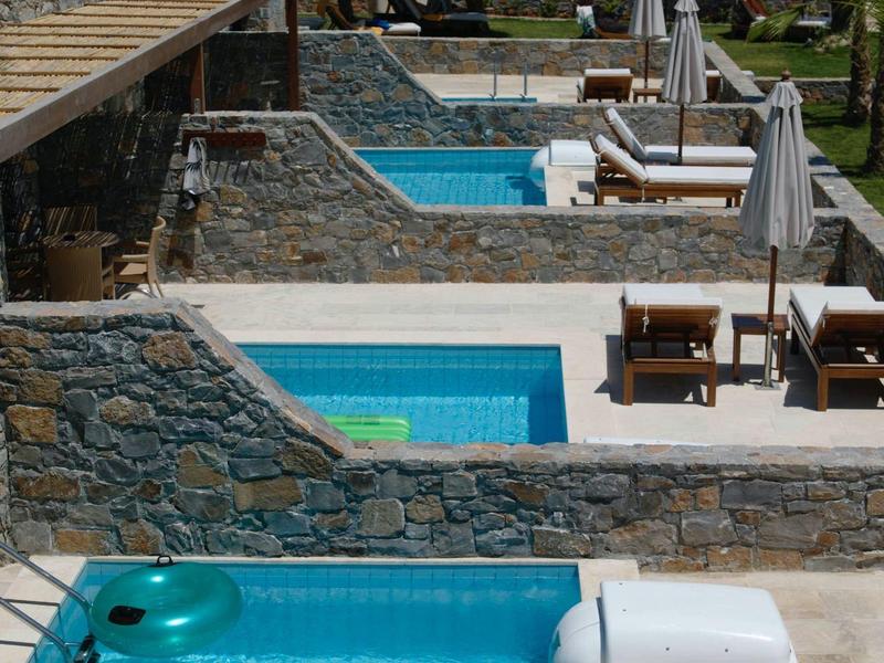 Filas de piscinas privadas junto a tumbonas y sombrillas en un hotel junto al mar.