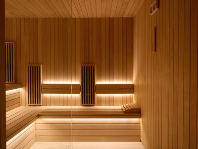 Moderní dřevěný interiér sauny s nepřímým osvětlením a opěrkami hlavy.