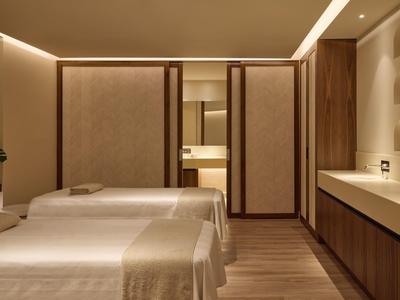 Moderně zařízený pokoj se dvěma jednolůžky a teplými dřevěnými prvky.