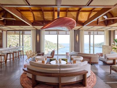 Helles, modernes Hotelrestaurant mit großer Fensterfront und Blick auf Wasser und Berge.
