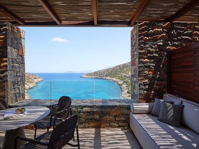 Gemütliche Aussicht auf das Meer von einer überdachten Terrasse mit Sitzbereich.