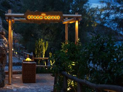 Osvětlený vstup do hotelu nebo resortu v zalesněné horské oblasti za soumraku.