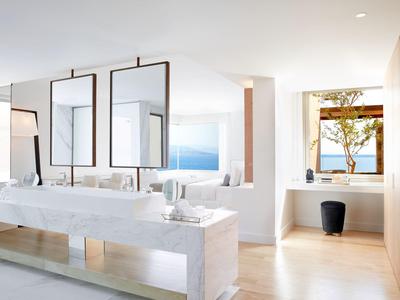 Modernes Badezimmer mit Doppelwaschbecken und großem Fenster mit Meerblick.