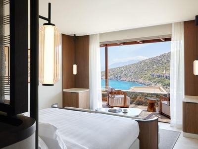 Helles Hotelzimmer mit Doppeltbett und Balkon mit Meerblick