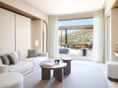 Helles Wohnzimmer mit beigen Möbeln, Blick auf Terrasse und Meer.