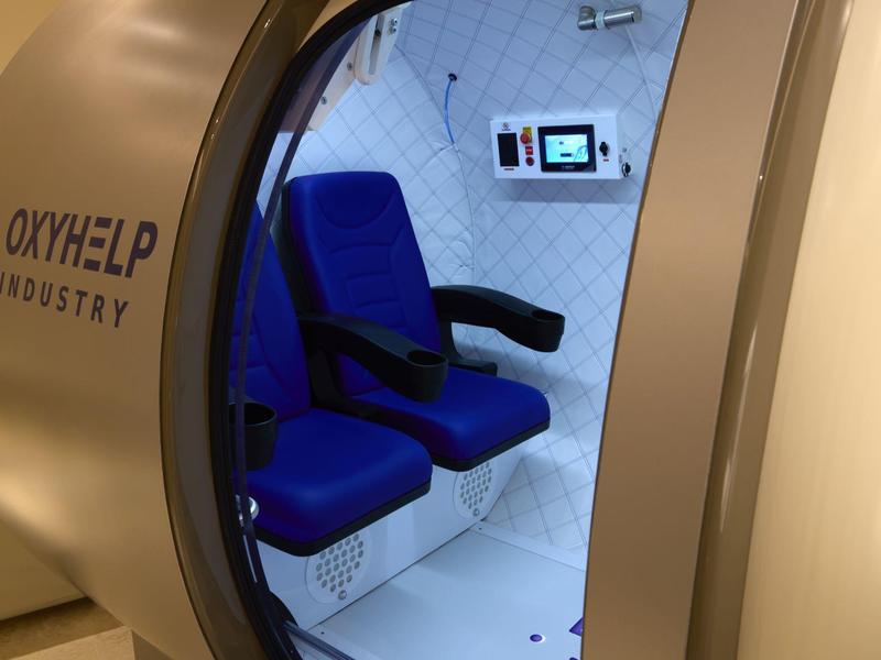 Kapslová relaxační kabina s modrými sedadly a ovládacím panelem pro hotely nebo wellness.