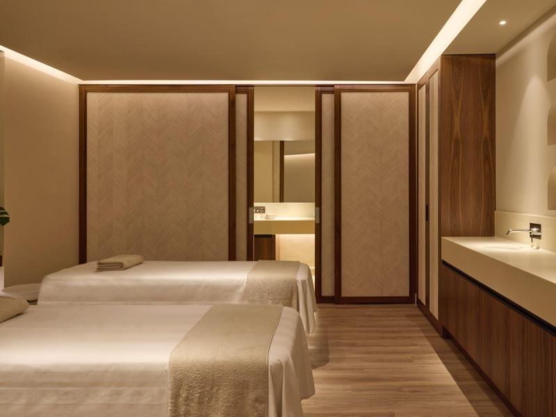 Moderně zařízený pokoj se dvěma jednolůžky a teplými dřevěnými prvky.