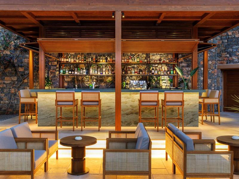 Moderní bar s útulným posezením a dřevěnými prvky za teplého osvětlení