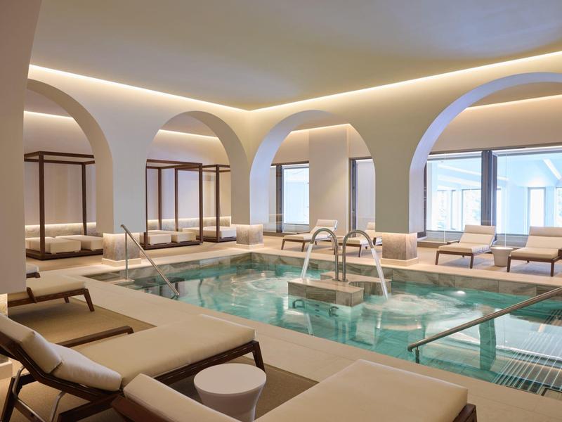 Elegantní vnitřní bazén s lehátky a příjemným osvětlením v moderním designu.