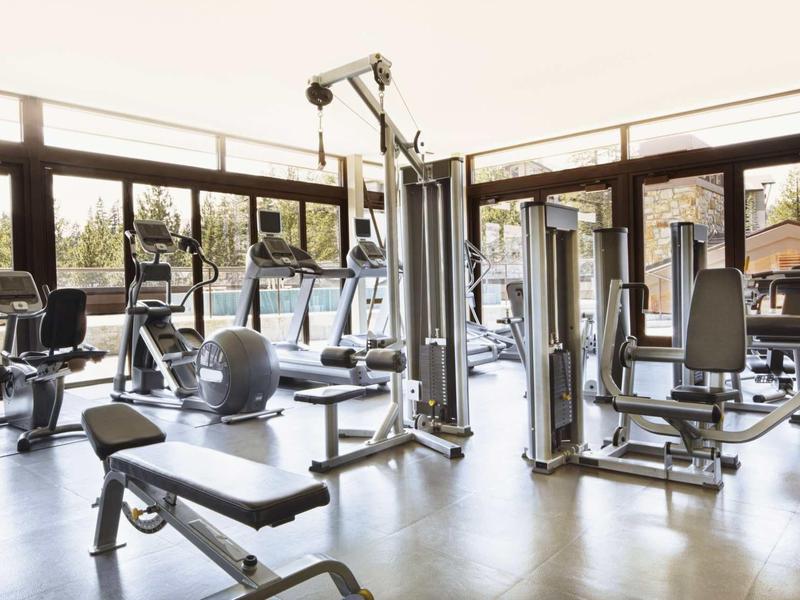 Moderne sportschool met apparatuur en grote ramen voor veel daglicht.