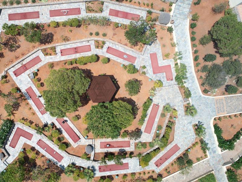 Vista aérea de un complejo hotelero con edificios blancos alargados y patios verdes.