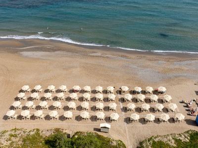 Une plage avec des parasols disposés régulièrement et vue sur la mer.