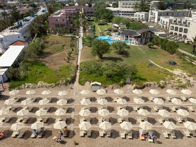 Widok z lotu ptaka na hotel z rzędami parasoli na piaszczystej plaży