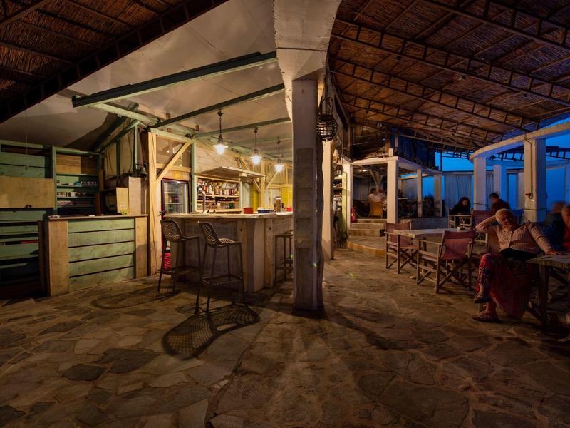 Przytulny bar na zewnątrz z ladą i miejscami do siedzenia o zmierzchu.