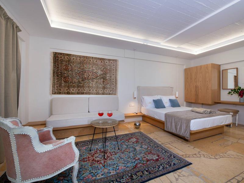 Nowoczesny pokój hotelowy z łóżkiem, sofą i dywanem.