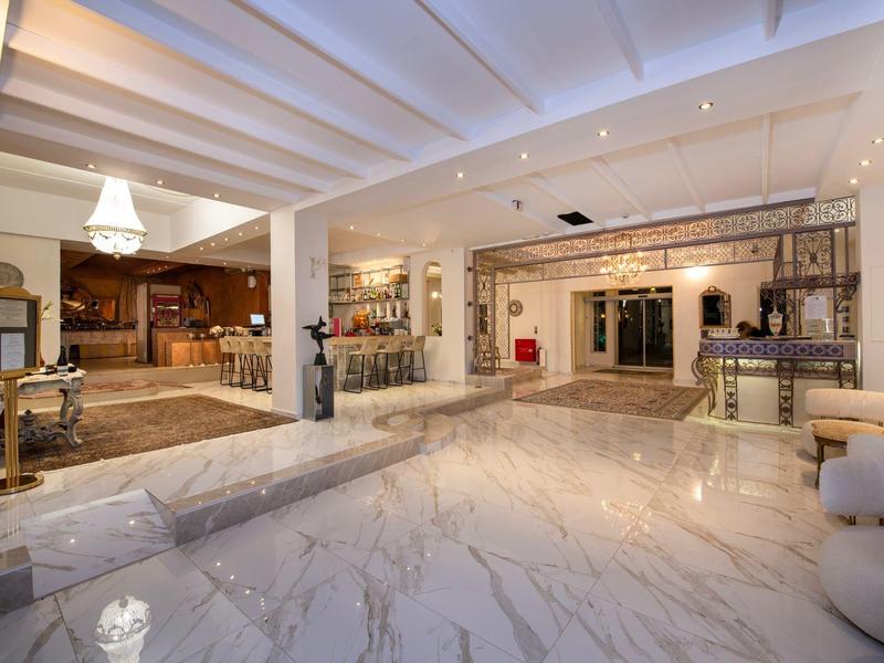 Jasna lobby hotelowa z marmurową podłogą, miejscem do siedzenia i nowoczesnym oświetleniem.