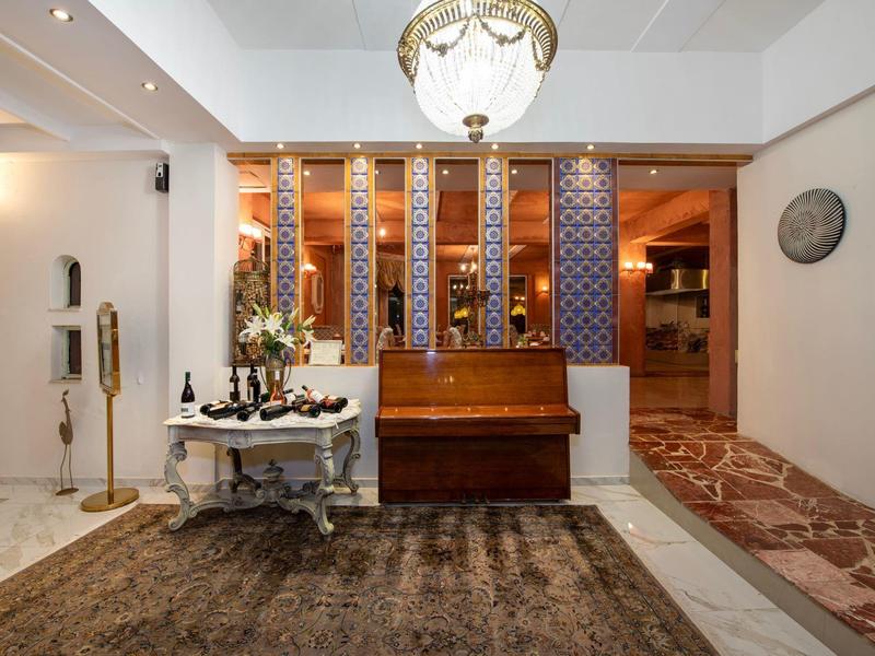 Elegancki hotelowy korytarz ze starym fortepianem, dywanem i dekoracyjnymi ścianami.