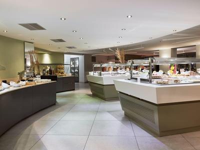 Modern buffet area with food display counters and contemporary lighting in a spacious room.
