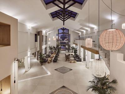 Spacious hotel lobby with modern seating, high ceilings, and warm lighting at night.