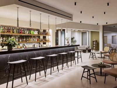 Modern hotel bar with stools, ambient lighting, and comfortable seating area.