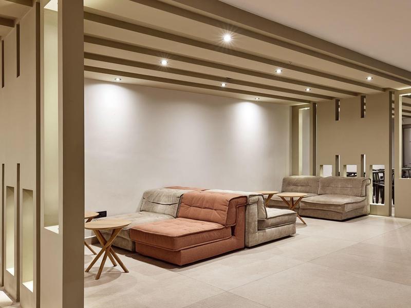 Modern hotel lobby with stylish seating, beige and brown tones, and warm lighting.