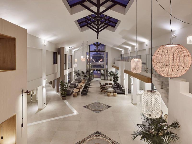 Spacious hotel lobby with modern seating, high ceilings, and warm lighting at night.