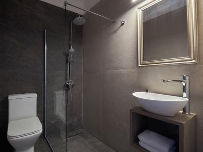 Nowoczesna łazienka z prysznicem bez brodzika, umywalką na drewnianej szafce i toaletą.