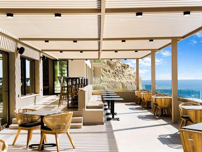 Terrazza moderna con posti a sedere e vista sul mare sotto un cielo limpido