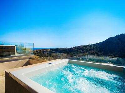 Moderne hot tub op terras met uitzicht op bergen onder een heldere blauwe lucht
