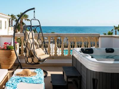 Terrazza con sedia sospesa, vasca idromassaggio e vista mare in una giornata di sole