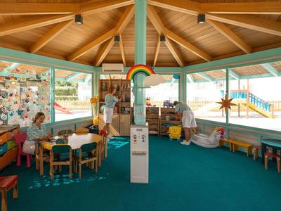 Area gioco luminosa con mobili in legno e decorazioni colorate in un centro benessere.