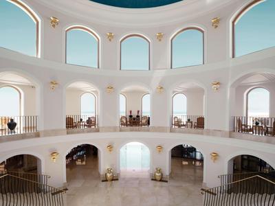 Velký světlý interiér se dvěma patry a kulatým střešním oknem, elegantní a otevřený.