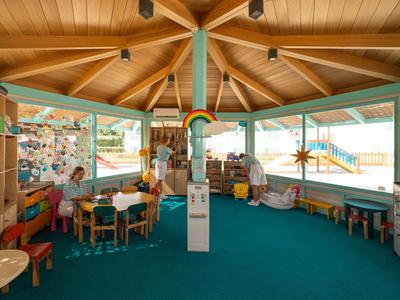 Prostorná šestiúhelníková dětská zóna s barevnými hračkami a nábytkem v hotelu.