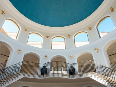 Helle Hotellobby mit rundem blauem Kuppeldach und kahlen weißen Wänden