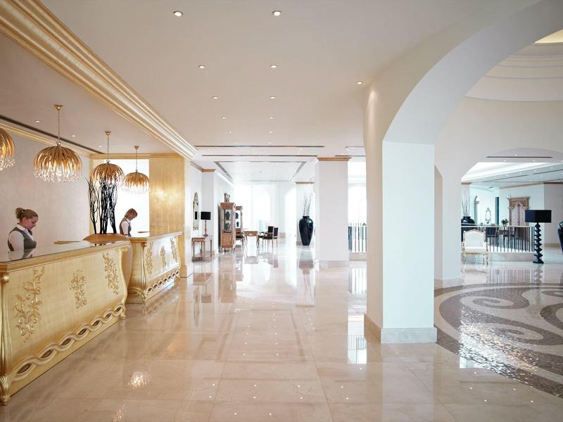 Elegante hall dell'hotel con reception, pavimento in marmo e arredamento elegante.