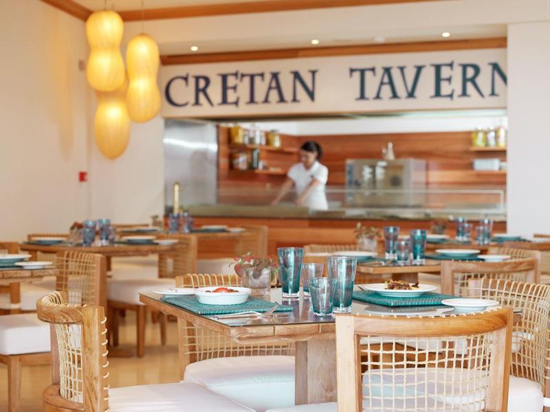 Vista interna di un locale luminoso e moderno con mobili in legno e tavoli apparecchiati.