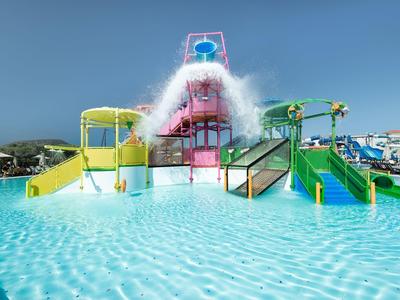 Buntes Wasserpark-Element mit Rutsche, Wasserspritzern und klarem blauen Pool unter blauem Himmel.
