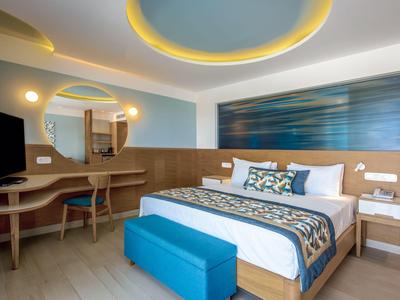 Modernes Hotelzimmer mit Doppelbett, Holzmöbeln und blauem Farbakzent.