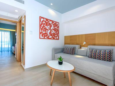 Modern eingerichtetes Wohnzimmer mit grauem Sofa, rundem Tisch und Holzvertäfelung.