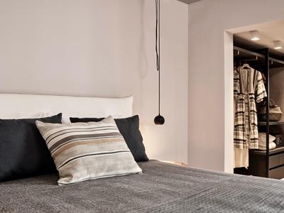 Chambre moderne avec lit confortable et dressing ouvert.