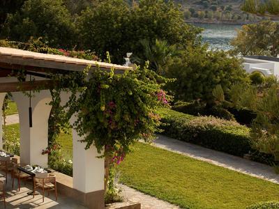 Balcone di un ristorante con vista su un giardino e acqua sullo sfondo in una giornata di sole