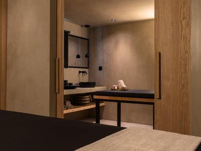 Espace bien-être moderne avec sauna, bancs en bois et éclairage tamisé.